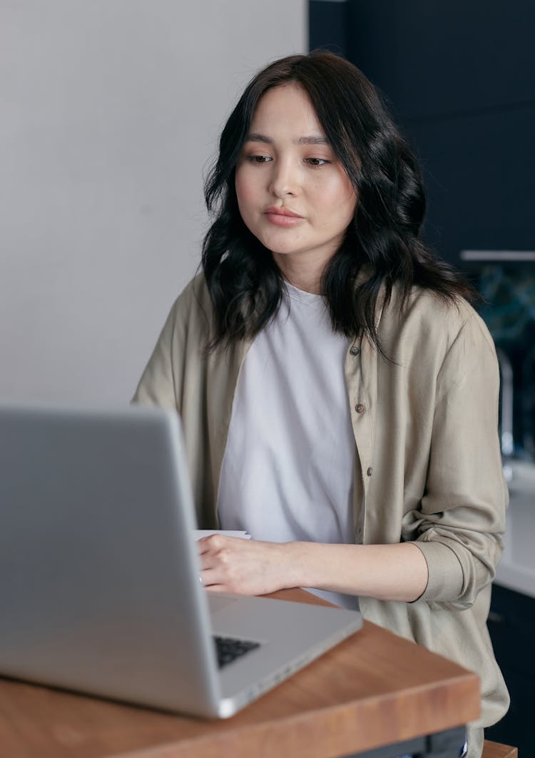 Woman In Beige Cardigan Using Laptop 