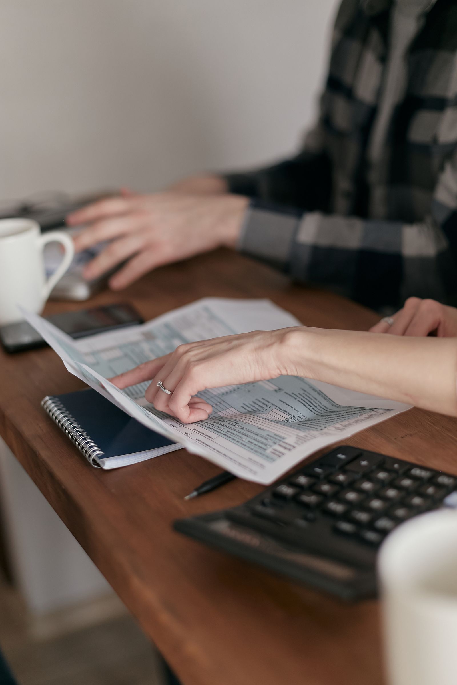 Hands working through documents and figures — reading the business before recommending change