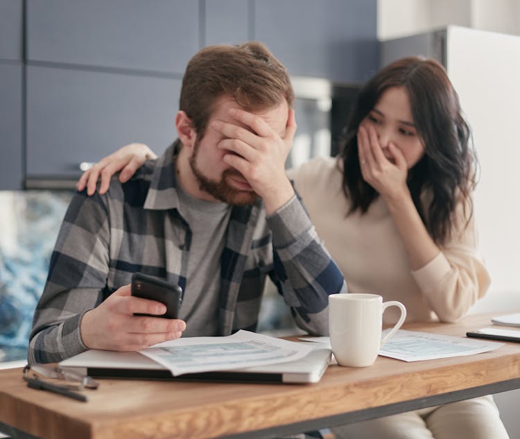 A Man Covering His Face In Frustration