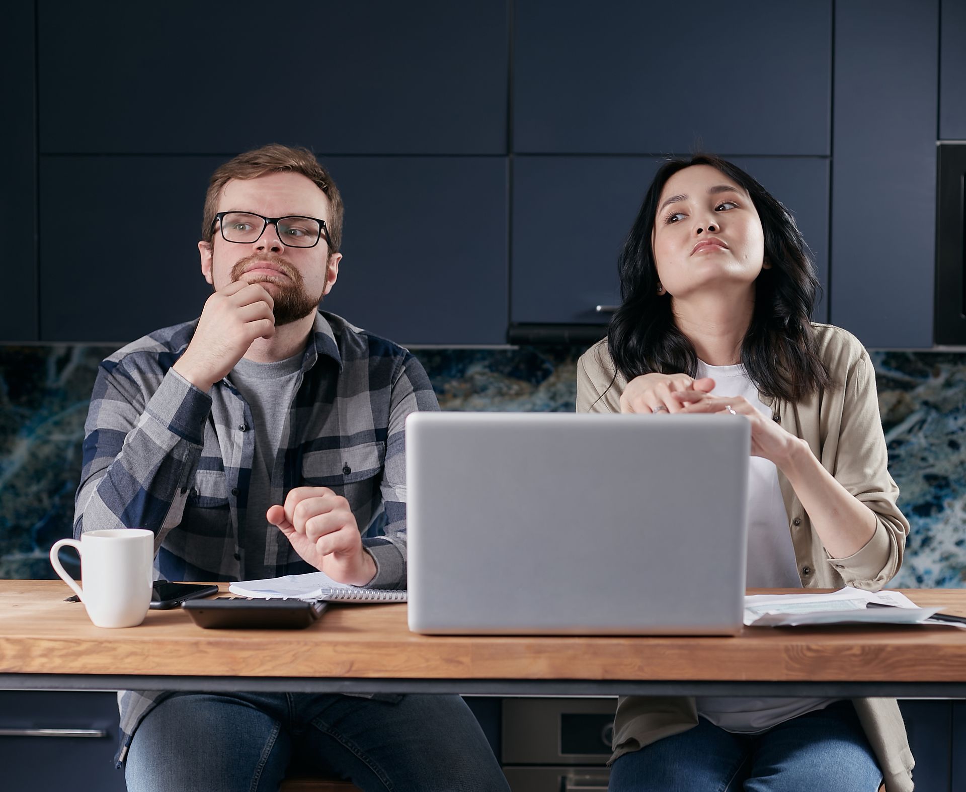 Two colleagues working together on a project in a modern office setting, deep in thought.