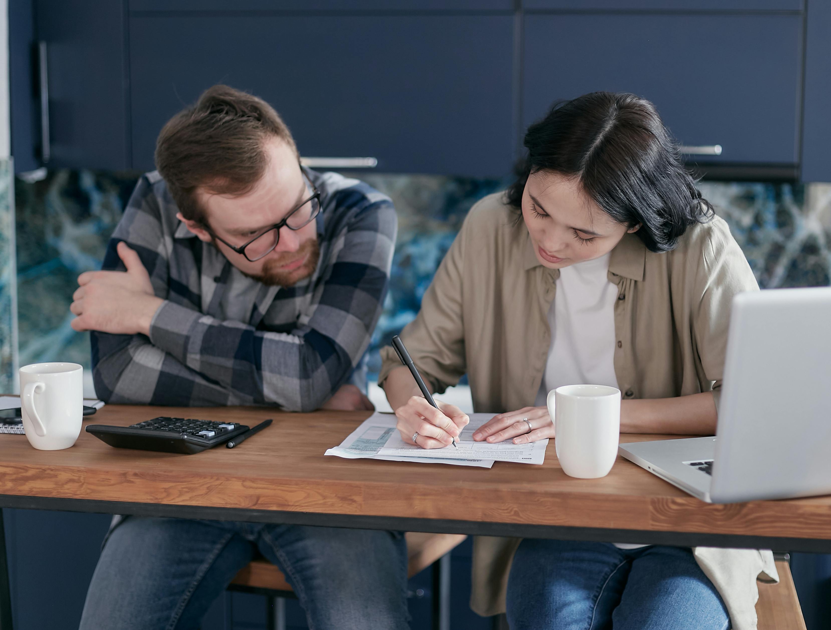 a woman filling out a form beside a man