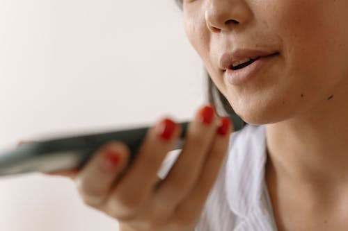 Close up of a Woman Speaking to the Mobile Phone Microphone