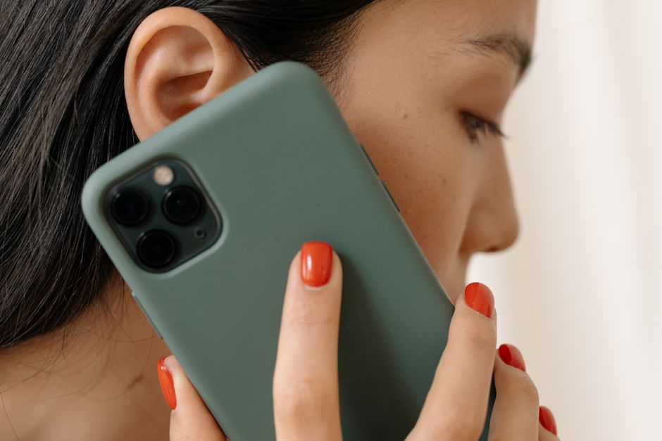 Close-up of an Asian woman holding a smartphone to her ear seems to be on a call.