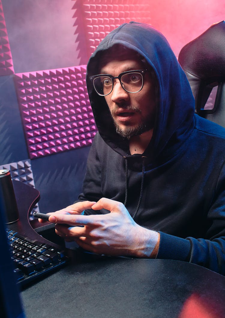 Man In Black Hoodie With Eyeglasses Using A Phone 