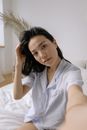 Woman in White Button Up Shirt Lying on Bed