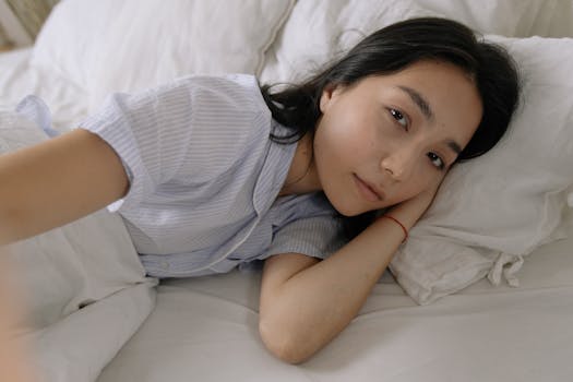 A serene portrait of a woman lying on white bed linen, embracing morning tranquility.