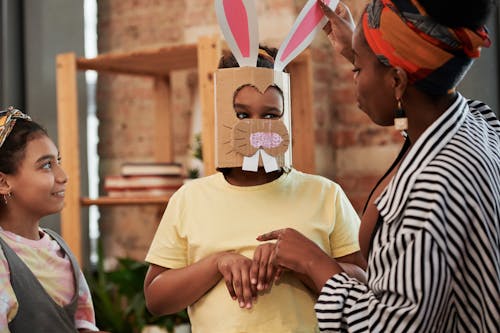 Girl Wearing A Bunny Mask Standing Beside A Girl And Woman