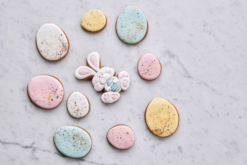 Free A collection of pastel-colored Easter egg and bunny-shaped cookies on a marble background. Stock Photo