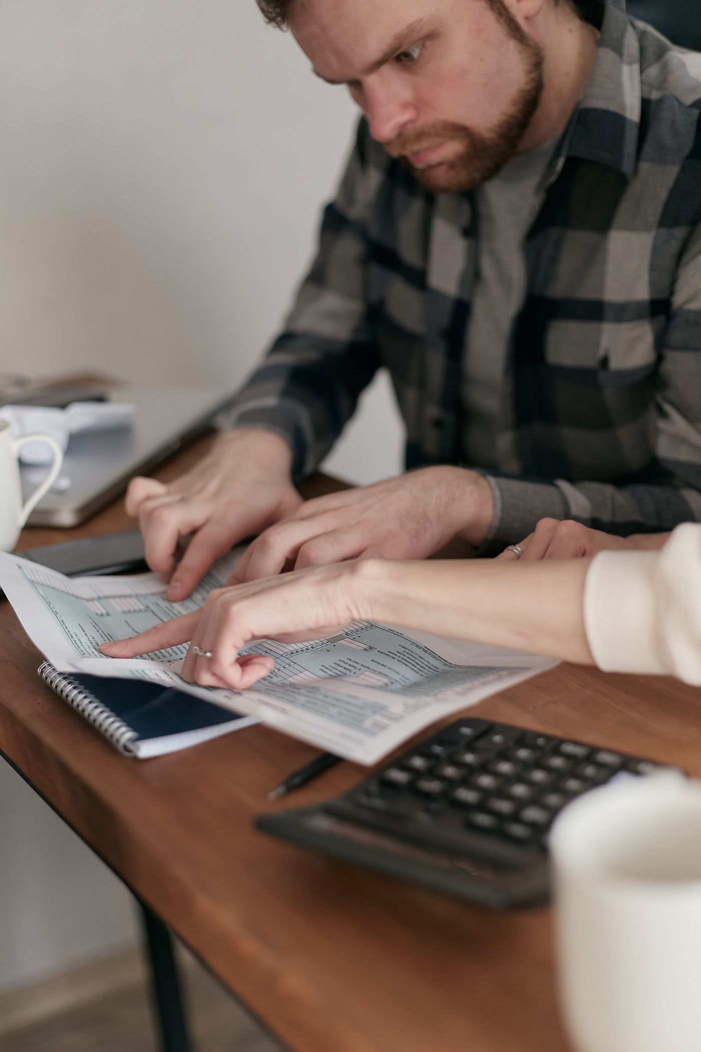 Două persoane care analizează documentele unui credit și calculează bugetul