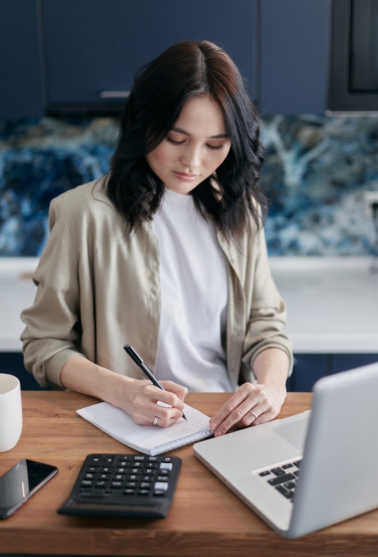 Woman Writing On A Notepad