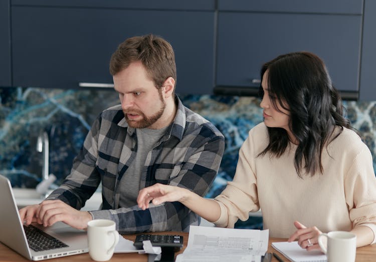 Colleagues Discussing And Working In Front Of A Computer Laptop