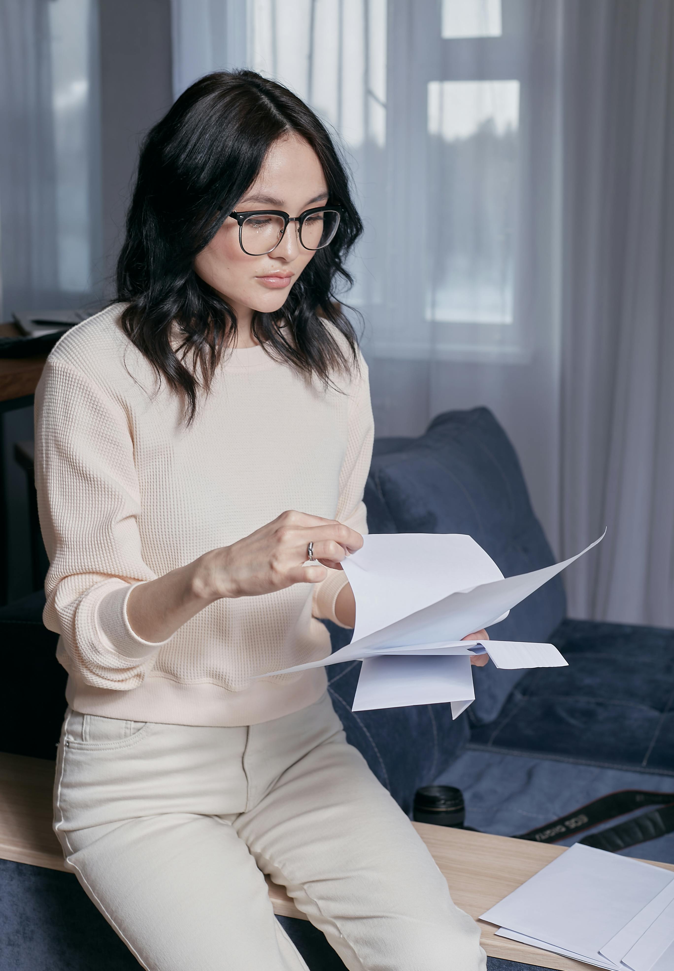 woman in beige long sleeve shirt holding white papers