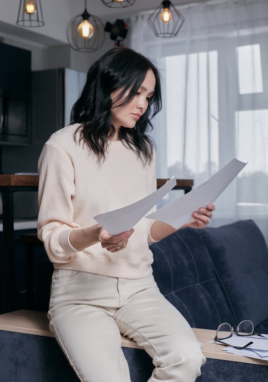 Free A Woman at Home Reading Documents Stock Photo