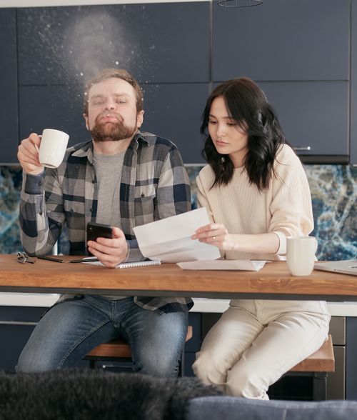 Free A young couple reviews bills and documents in their kitchen, expressing financial stress and concern. Stock Photo