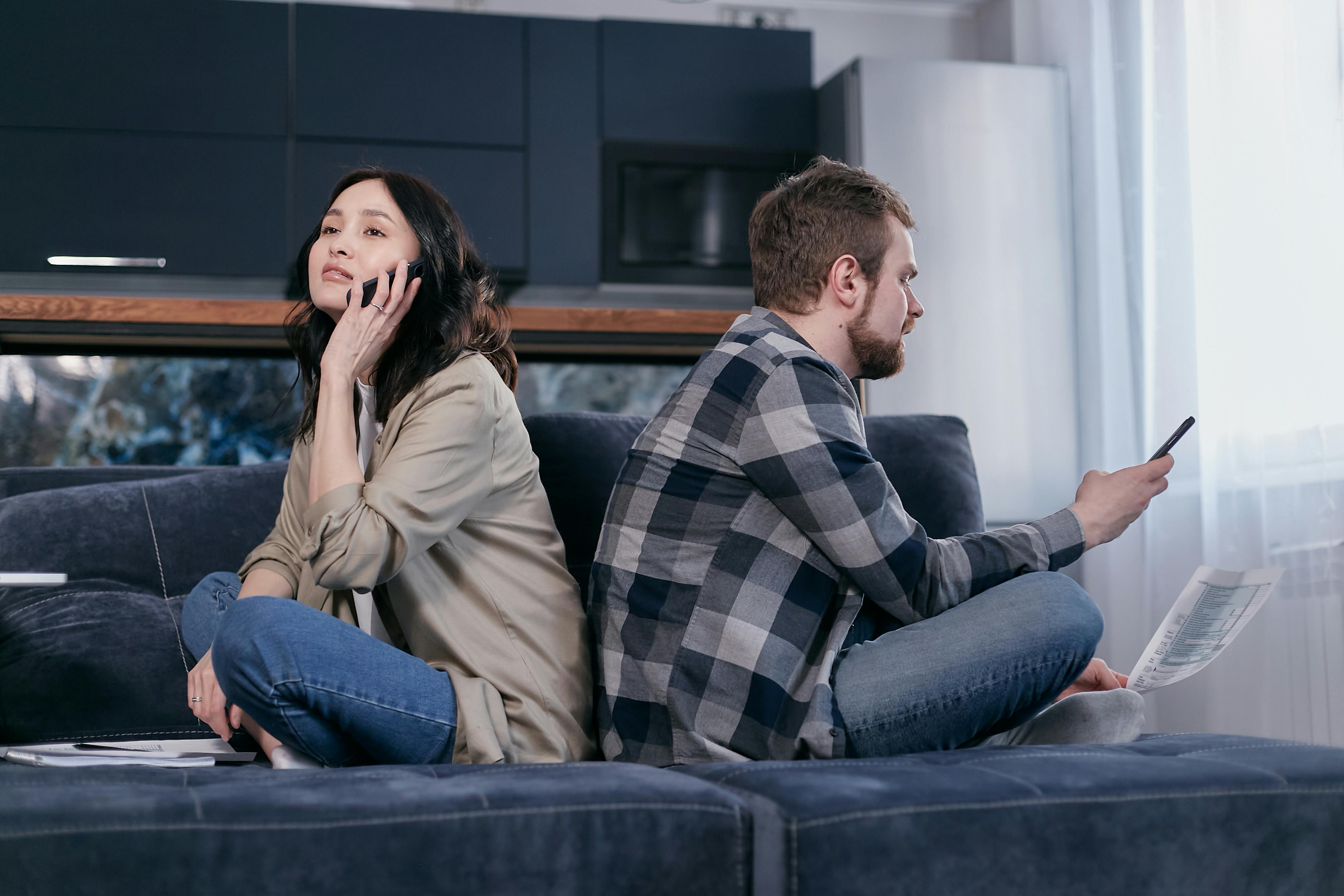 man and woman sitting on blue couch