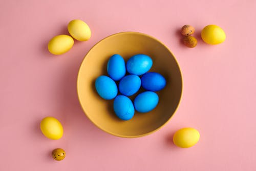 Blue Eggs On Bowl With Yellow Eggs On Pink Background