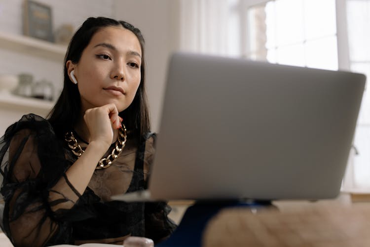 Woman Wearing Air Pods While Using Laptop 