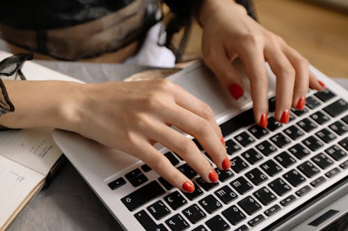 Woman with Manicured Nails Using a Laptop