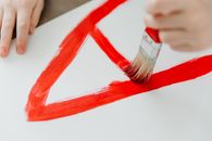 A Child Writing a Letter using a Paintbrush