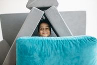 Smiling Boy Playing with Cushions
