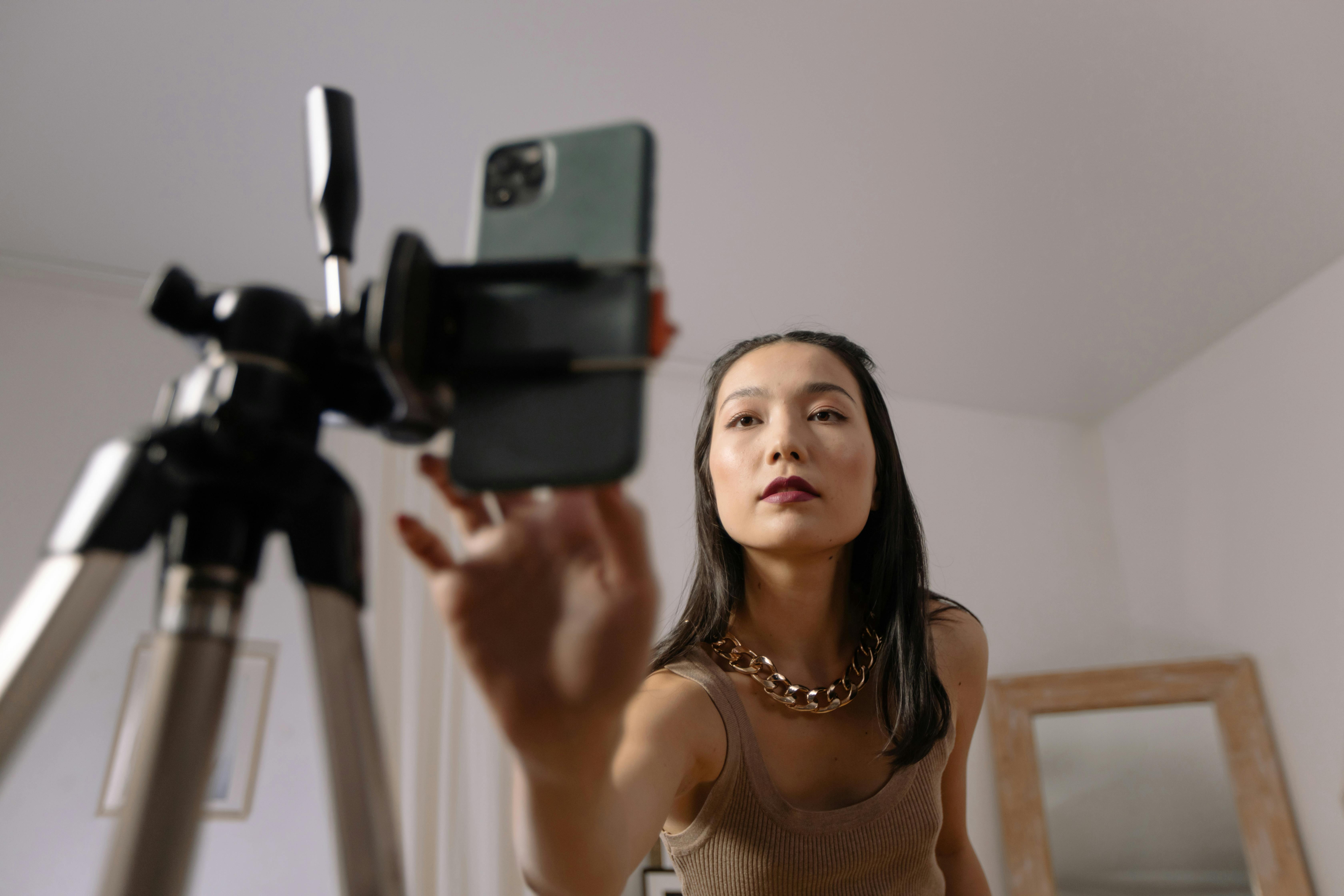 A person using a smartphone attached to a tripod