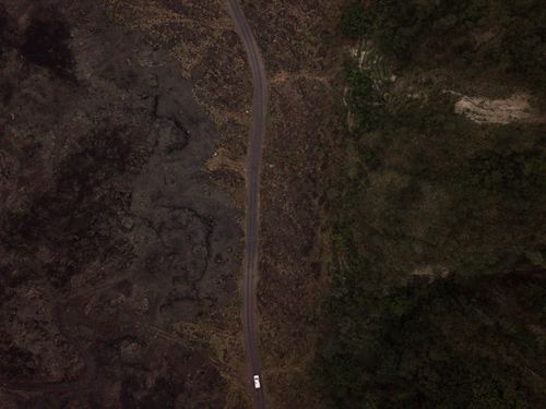 Free Drone shot capturing a road dividing barren and lush areas, emphasizing contrast in nature. Stock Photo
