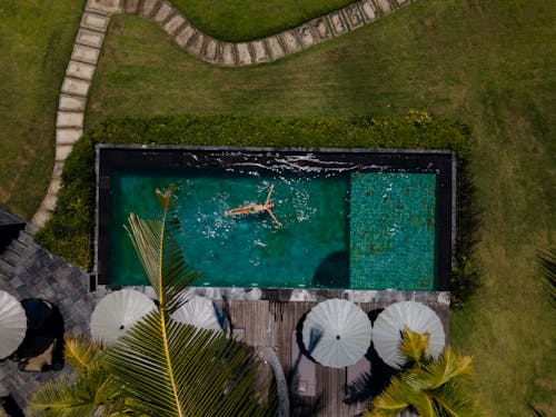 Aerial Photography of Woman Floating on Pool 