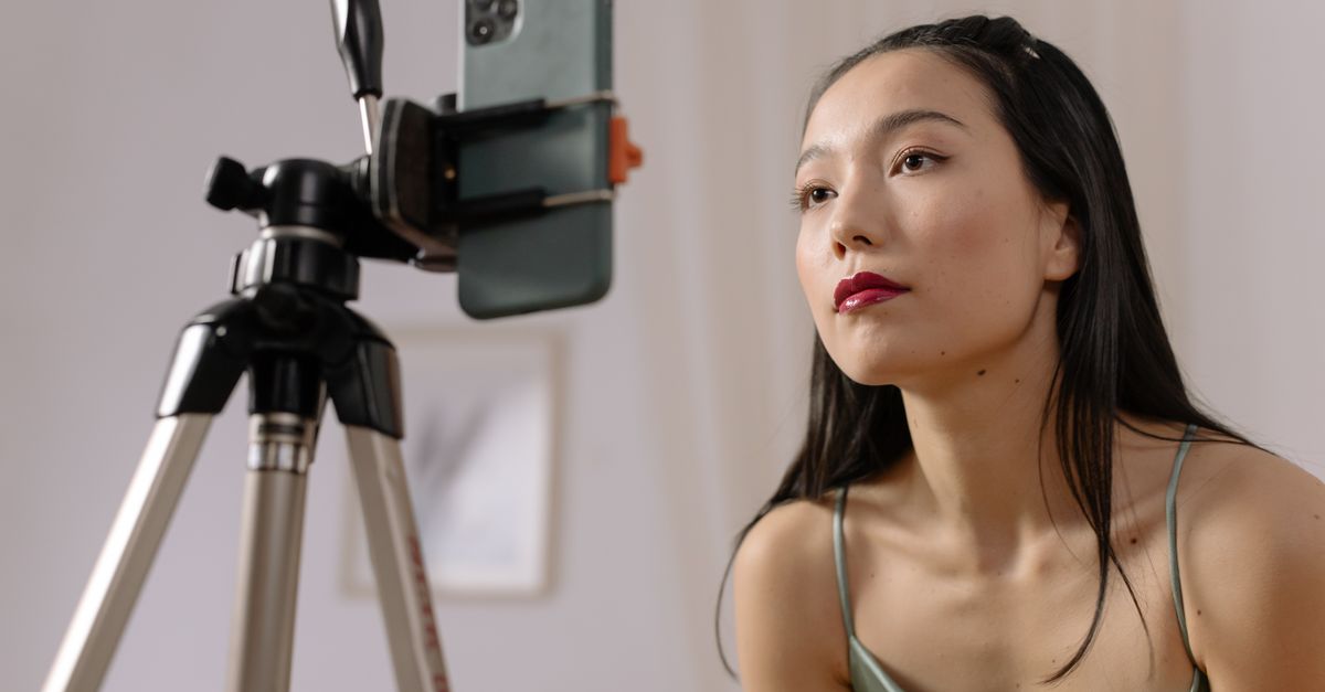 A creator records a UGC video on a smartphone mounted to a tripod