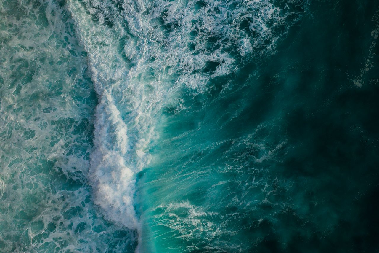 dynamic aerial view capturing the vibrant movement of crashing ocean w