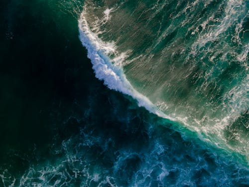 Drone Shot of Waves Crashing in a Blue Ocean