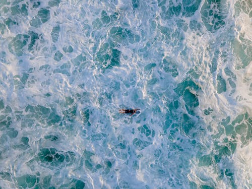 Aerial Shot of Person Surfing on the Ocean 