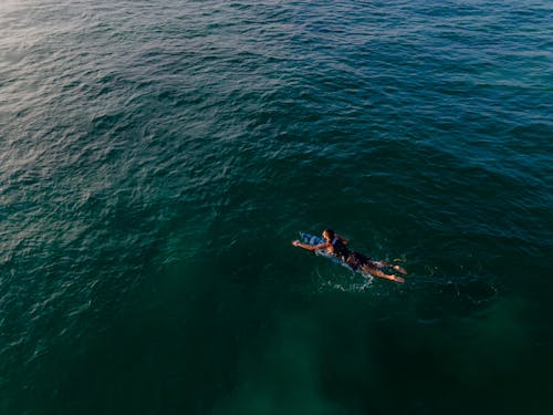 Man Surfboarding on Open Seas