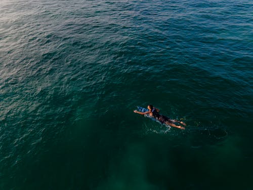 Man Surfboarding on Open Seas