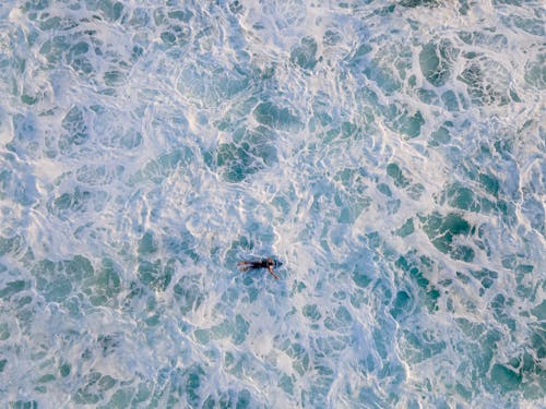 An Aerial Photography of a Person Surfing on the Sea