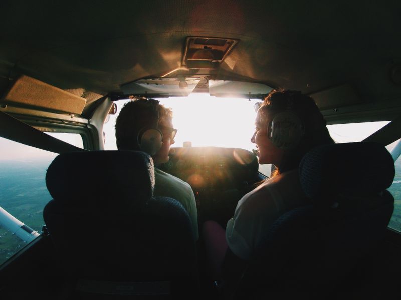 Two pilots in a private jet cockpit at sunrise