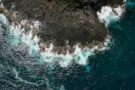 海浪拍打崎岖海岸线的令人惊叹的鸟瞰图，展示了大海和岩石海岸的融合