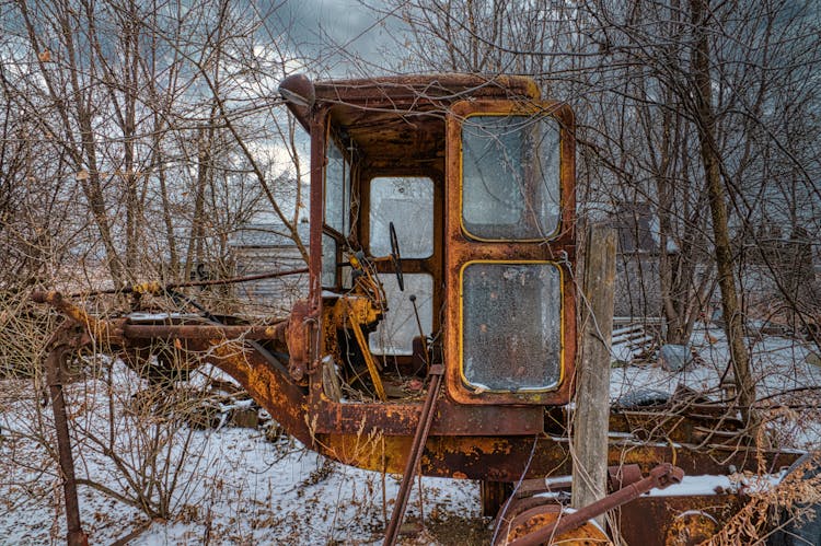 Brown And White Vintage Broken Tractor On Snow Covered Ground