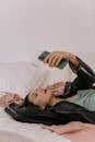 Woman in Black Leather Jacket Lying on Bed