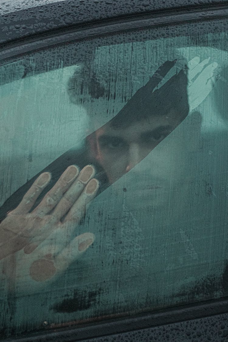 Ethic Man Looking Through Misted Window Of Car