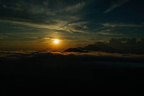Free Breathtaking view of a sunset over mountains, with clouds beneath. Stock Photo