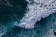 鸟瞰强大的海浪撞击岩石，捕捉到大自然力量的本质