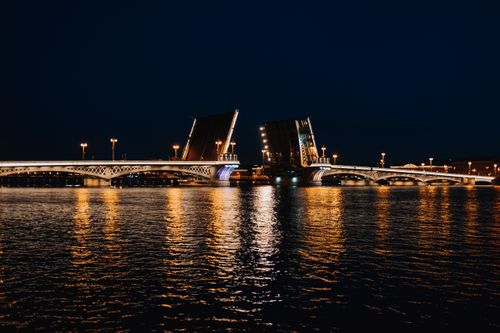 Free Stunning nighttime view of the illuminated Annunciation Bridge in Saint Petersburg, Russia, reflecting on the river. Stock Photo