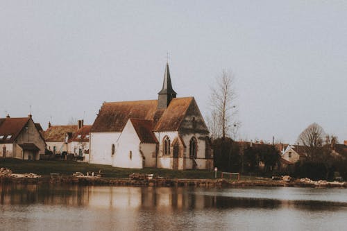 Old chapel near pond and buildings in town