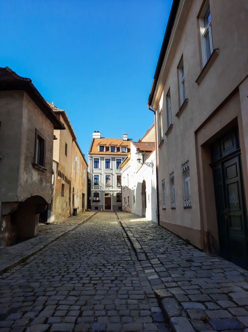 Free A picturesque cobblestone street lined with historic buildings in a quaint European town. Stock Photo