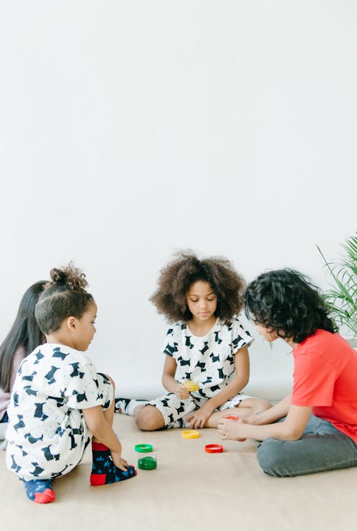 Children Sitting on White Floor Playing