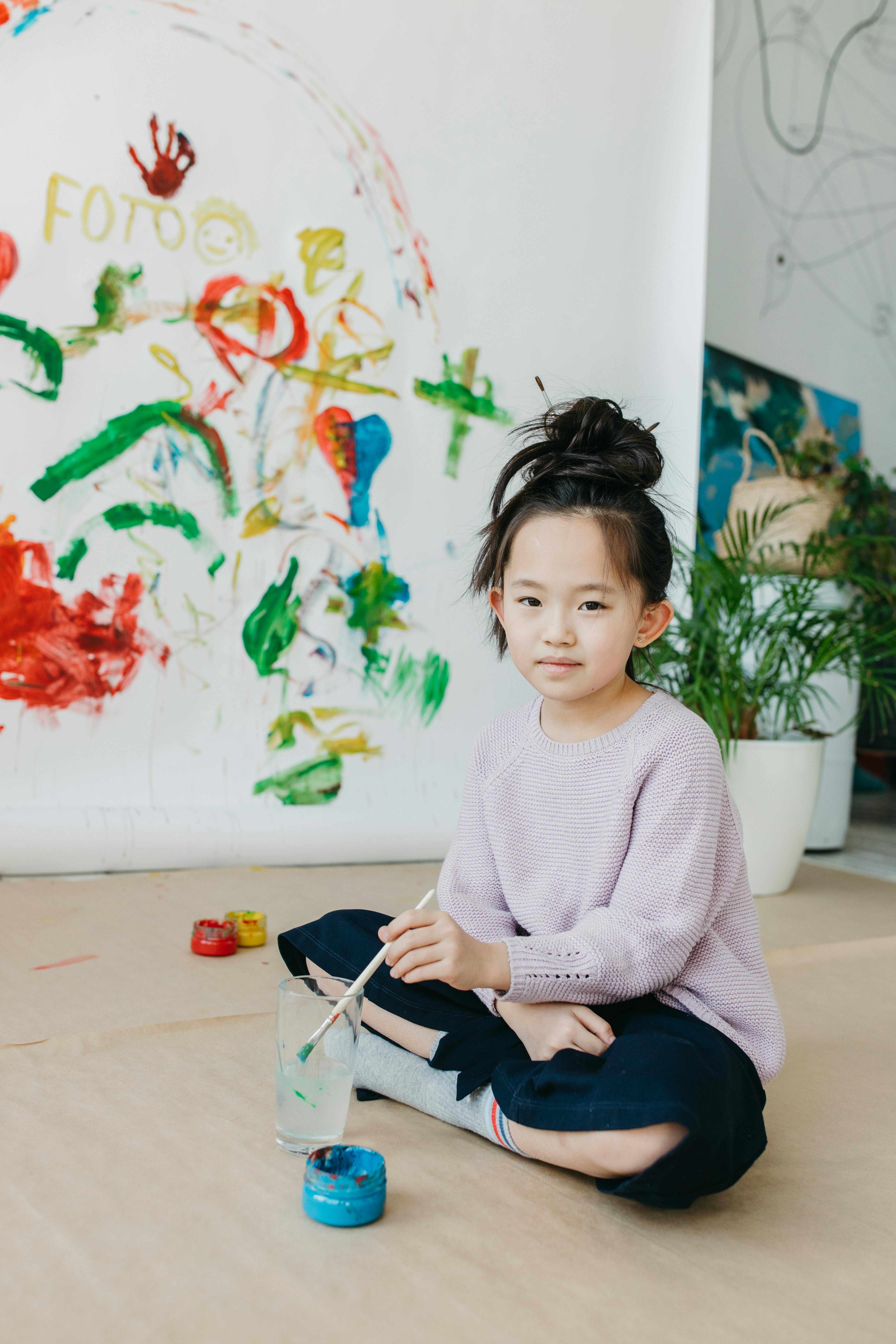 a girl holding a paint brush