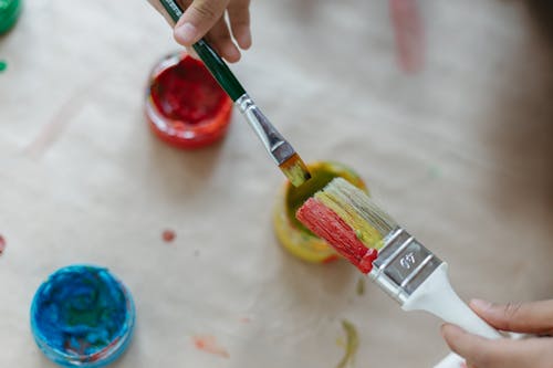 A Person Holding Paint Brushes