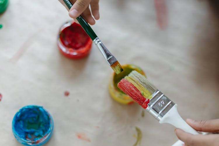 A Person Holding Paint Brushes