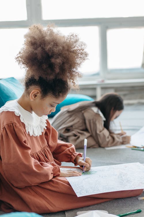 A Young Girl Drawing on a White Paper