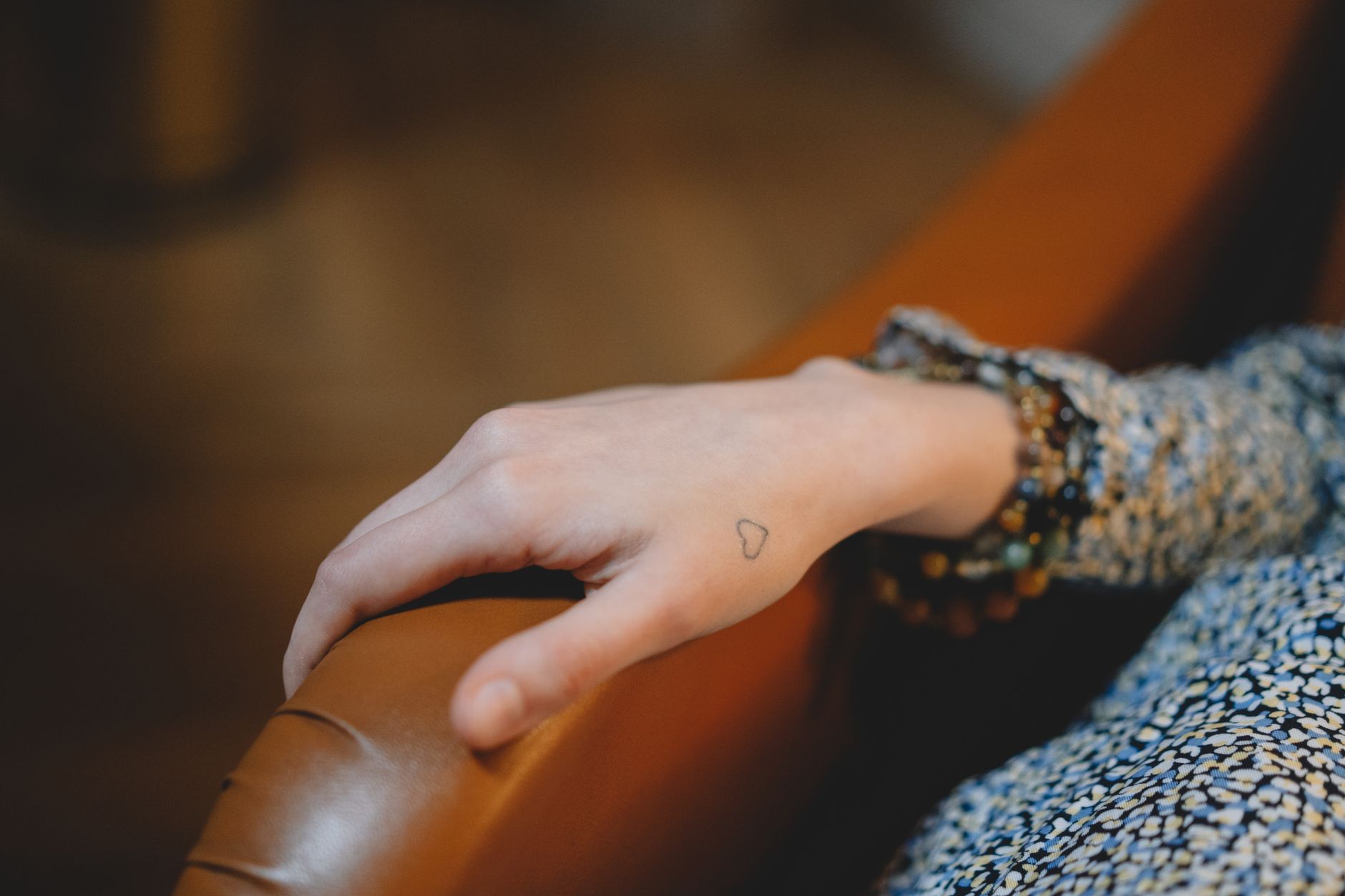Petit tatouage cœur minimaliste au trait fin sur le poignet d'une femme